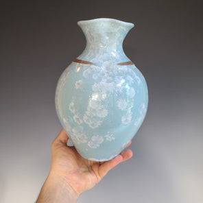 A light blue porcelain vessel with a ring of gold luster under the neck.