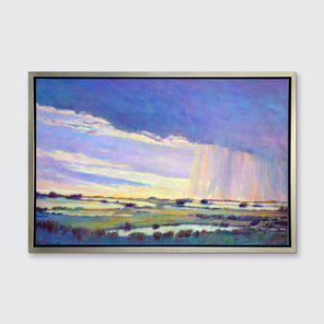 A blue, purple and yellow abstract landscape print in a silver floater frame hangs on a white wall.