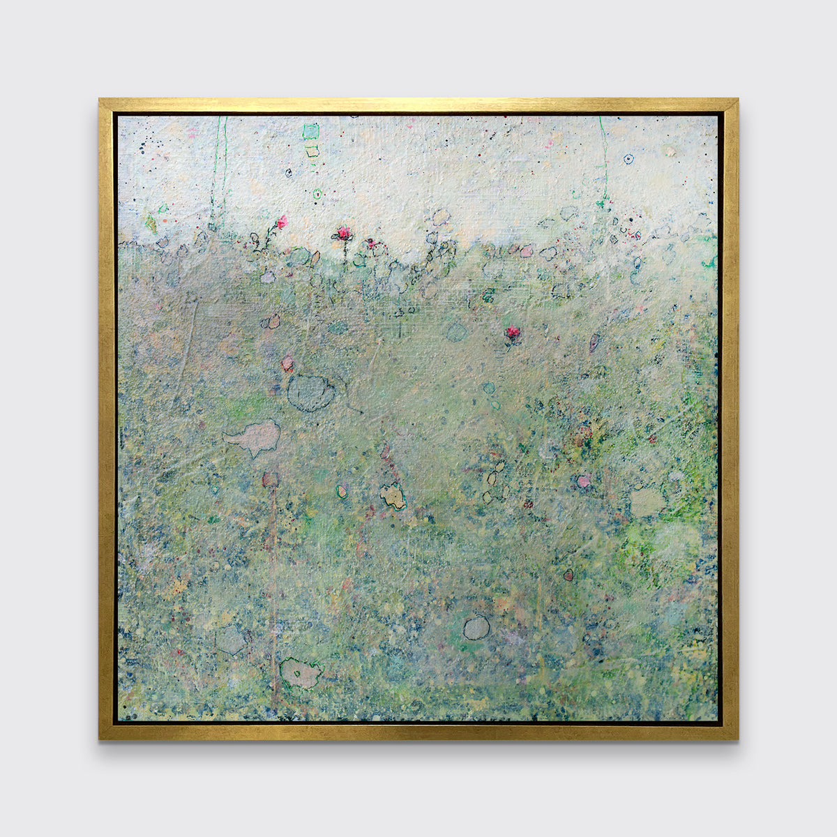 A green abstract landscape print in a gold floater frame hangs on a white wall.
