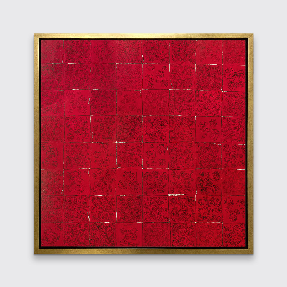 A red and black abstract geometric print in a gold floater frame hangs on a white wall.