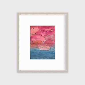 A pink, blue and black abstract landscape print in a silver frame with a mat hangs on a white wall.