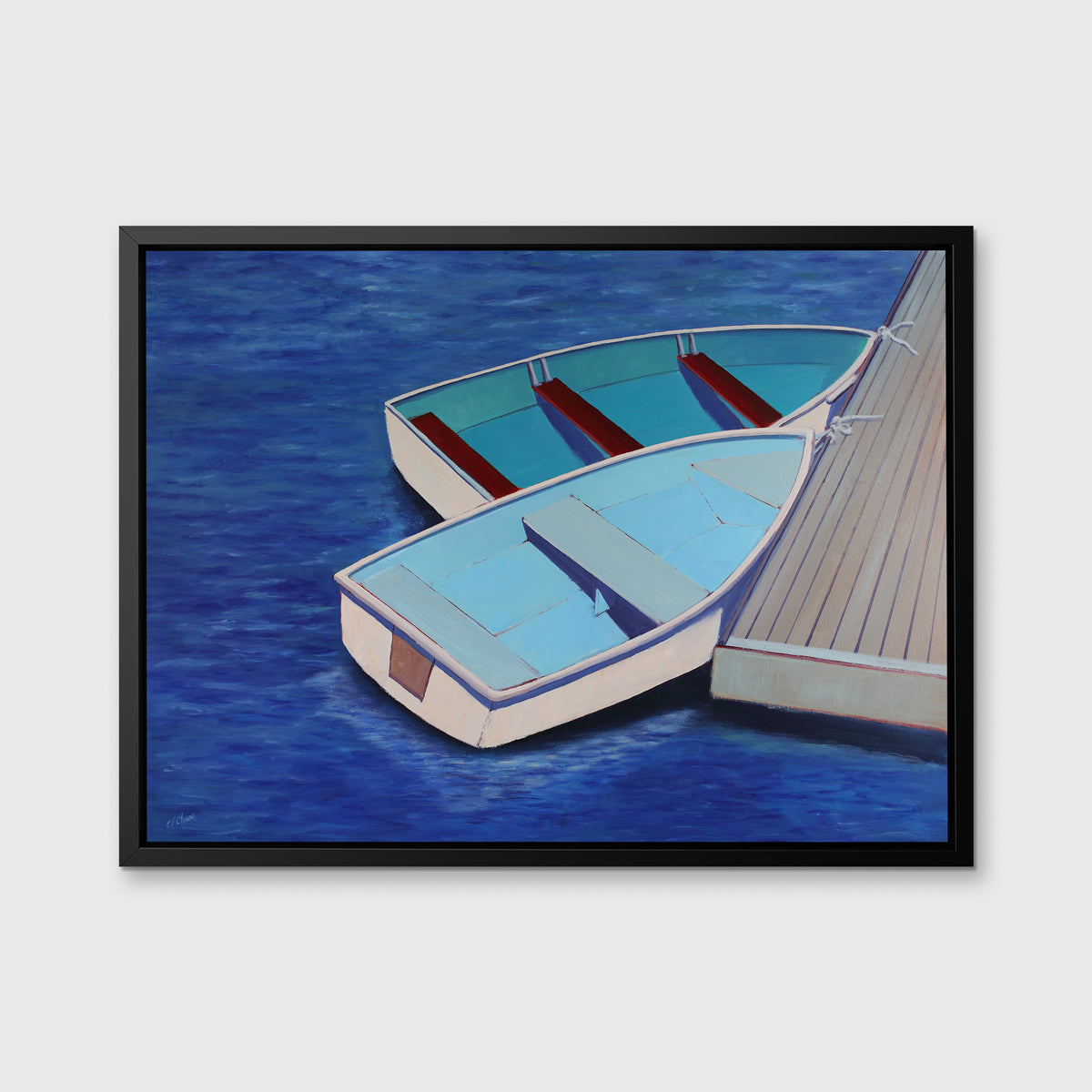 A blue, light blue and beige contemporary nautical print of two docked rowboats in a black floater frame hangs on a white wall.