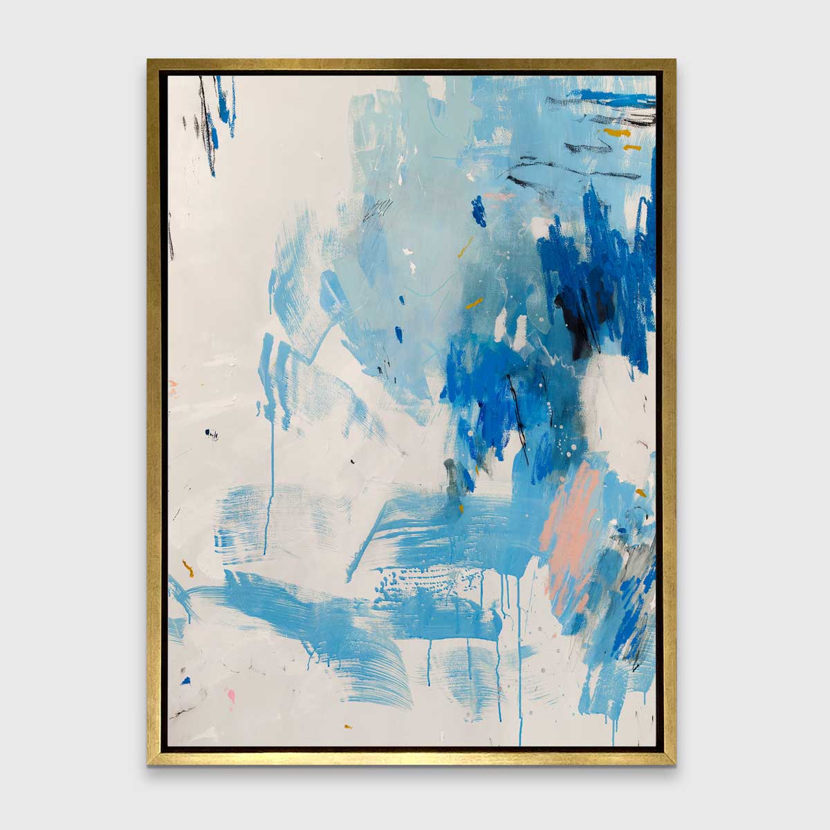 A blue, peach and white abstract print in a gold floater frame hangs on a white wall.