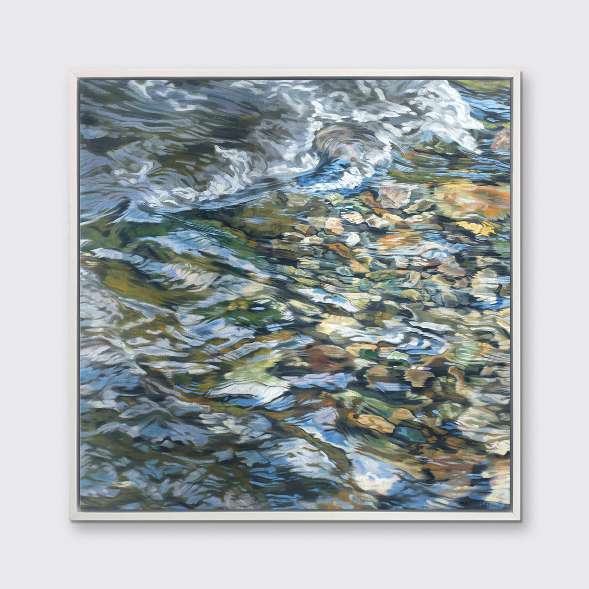 An abstracted riverbed print in a white floater frame hangs on white wall.