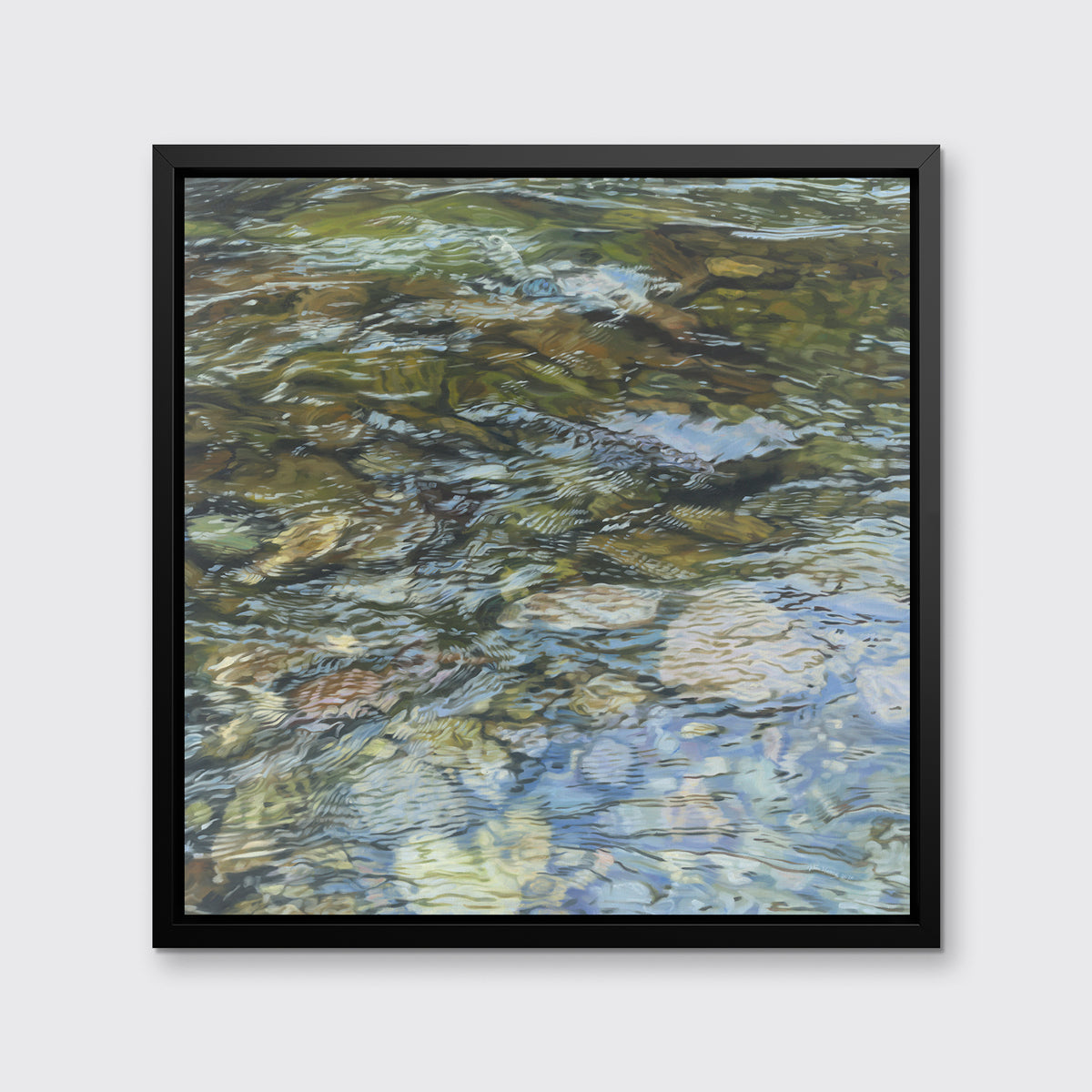 A green, brown, beige and white abstract river rock in water print in a black floater frame hangs on a white wall.