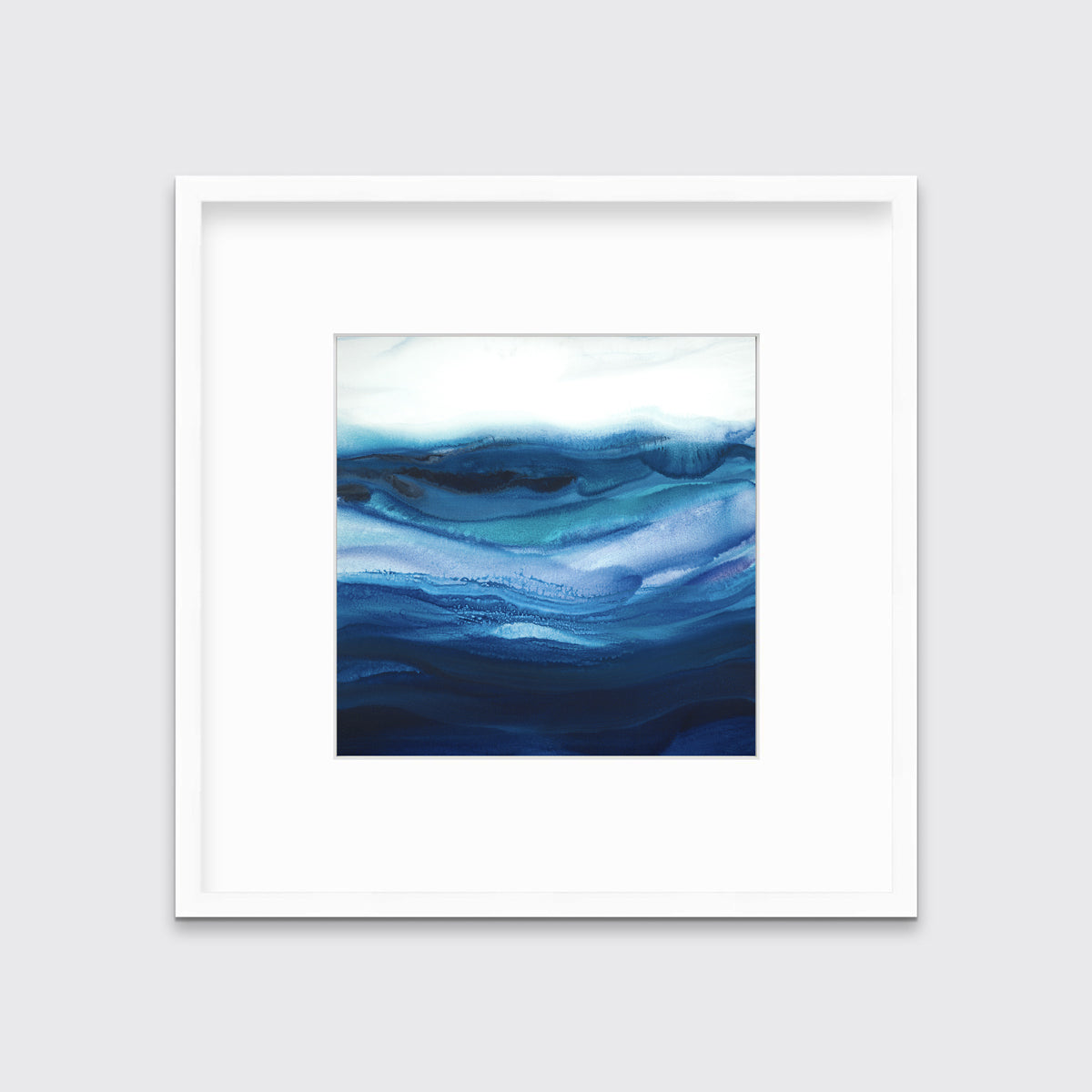 A blue, teal and white abstract print in a white frame with a mat hangs on a white wall.