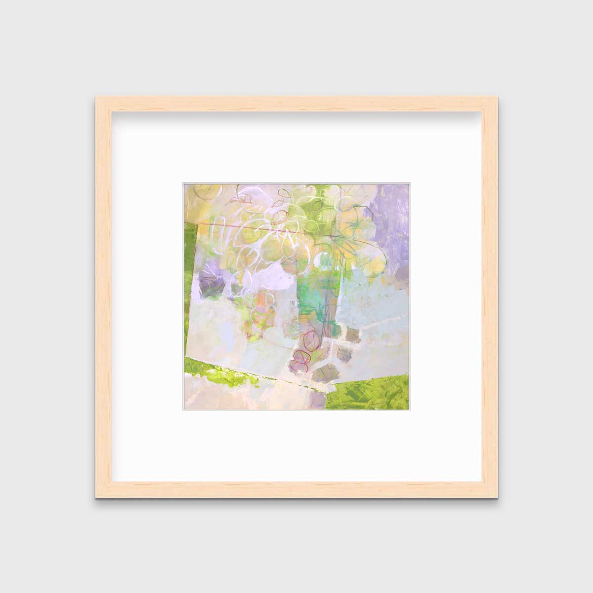 A light yellow, lavender and green abstract floral print in a natural wood frame with a mat hangs on a white wall.
