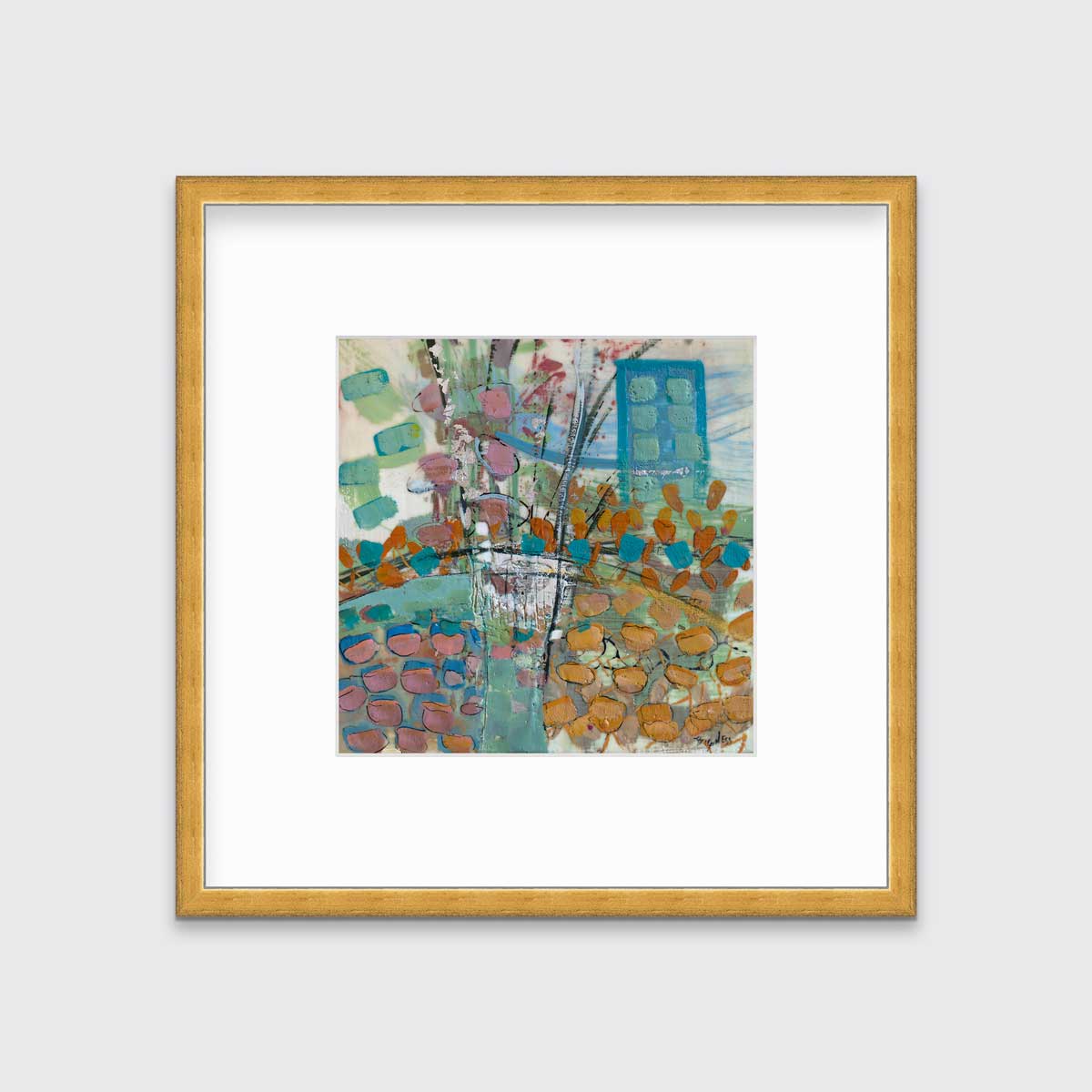 A multicolored abstract print, matted and framed in a gold frame hangs on a grey wall.