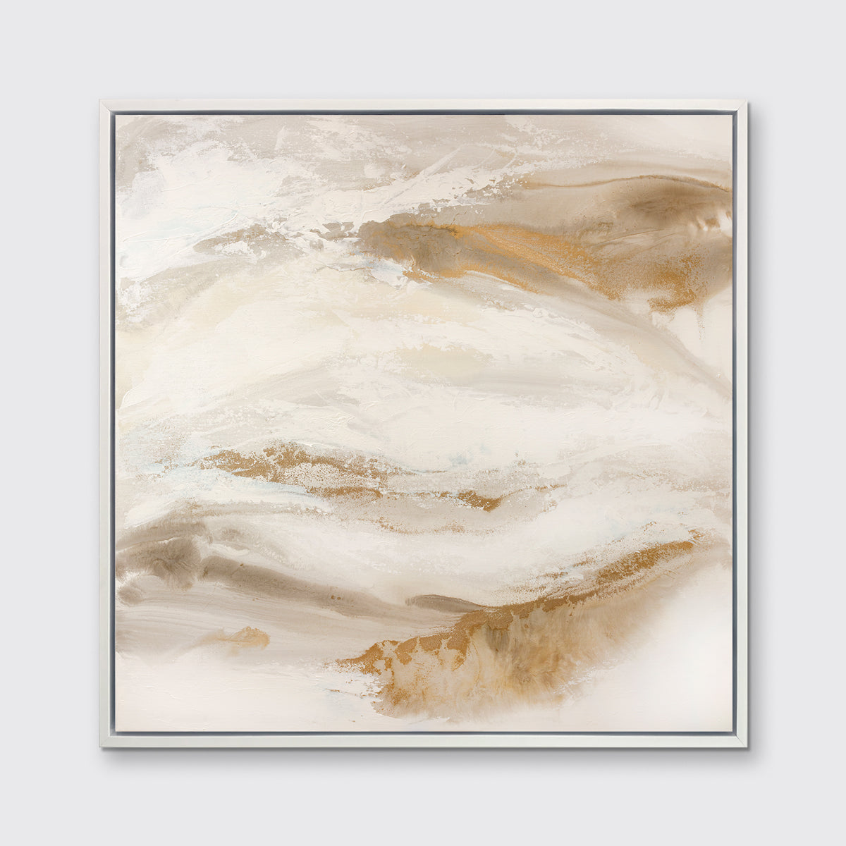 A gold, silver, white and beige abstract print in a white floater frame hangs on a white wall.