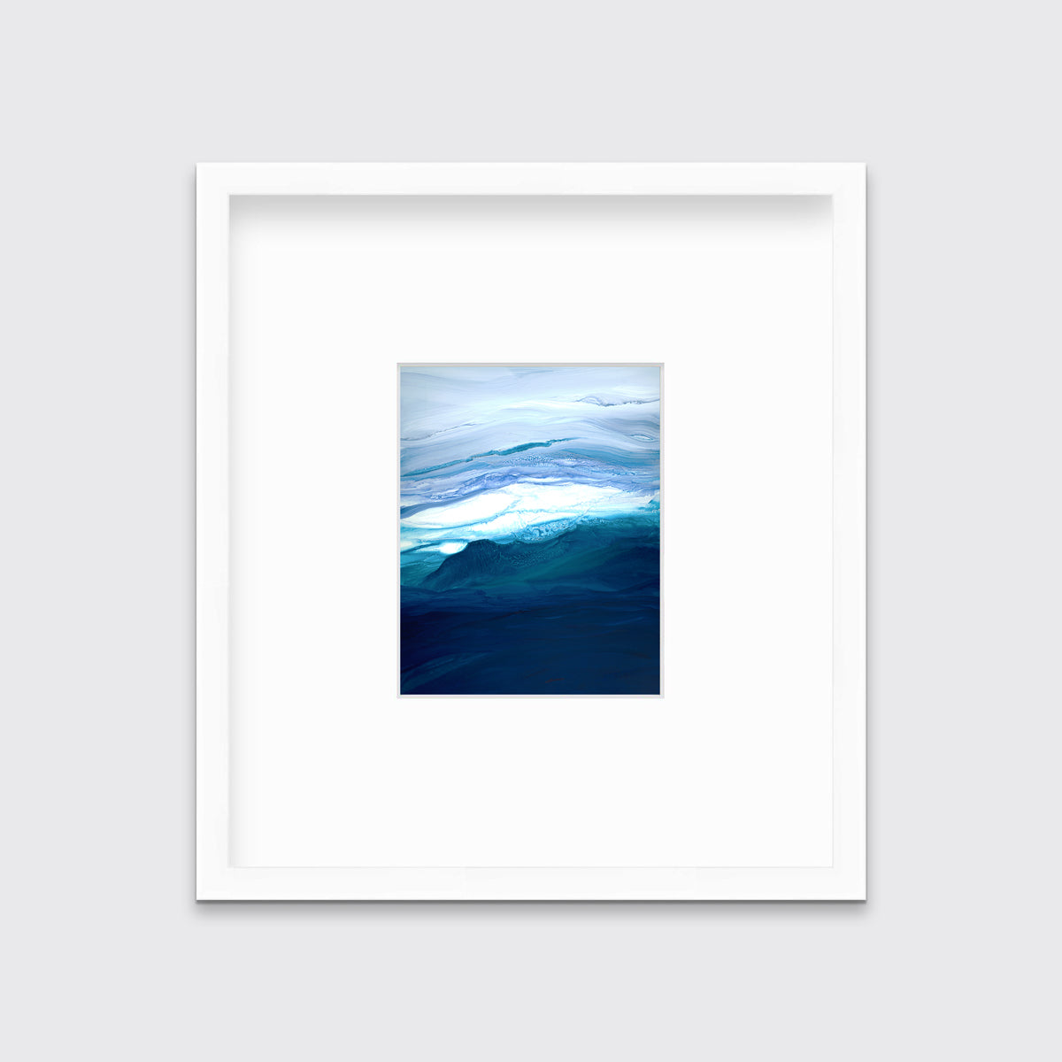 A blue, teal, lavender and white abstract print in a white frame with a mat hangs on a white wall.