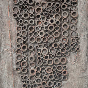 A grey and light rust orange abstract painting with embedded wood circles by Stanley Bate.