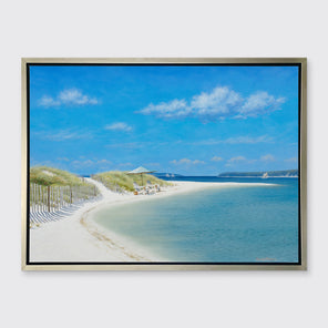 A blue, beige and light green contemporary seascape print in a silver floater frame hangs on a white wall.