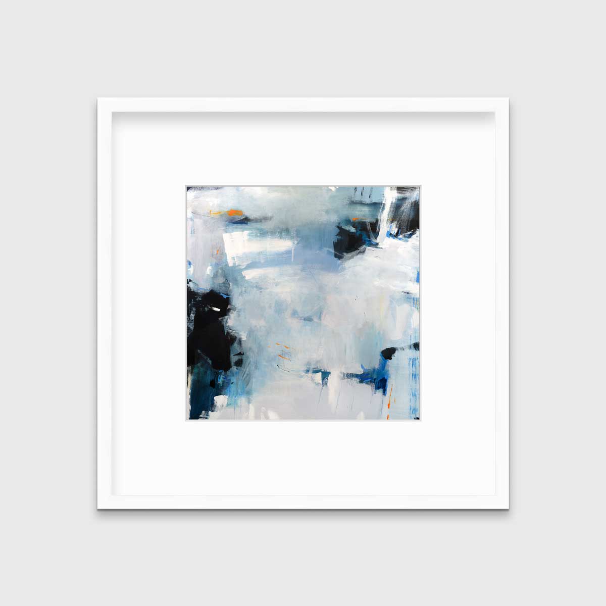 A blue and white abstract print in a white frame with a mat hangs on a white wall.