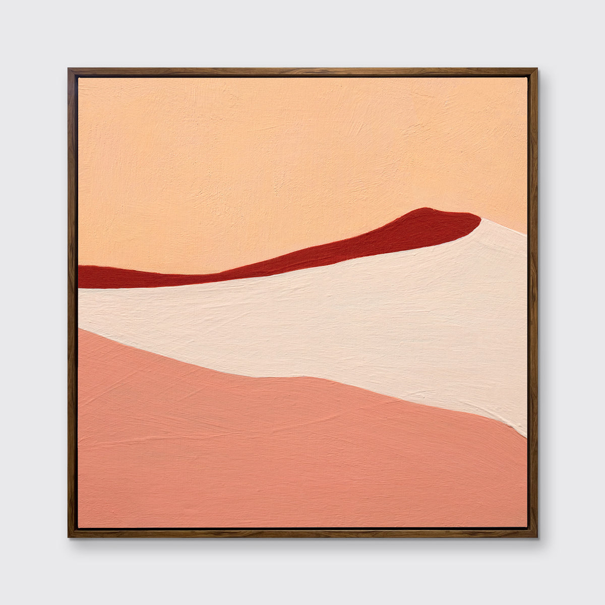 A red, peach and beige abstract print in an oak wood floater frame hangs on a white wall.
