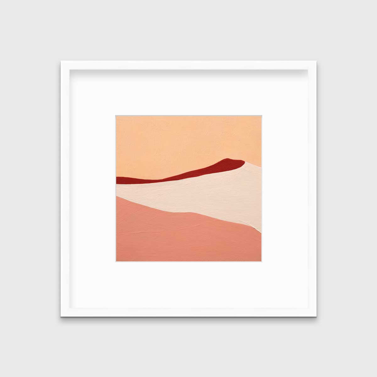 A red, peach and beige abstract print in a white frame with a mat hangs on a white wall.