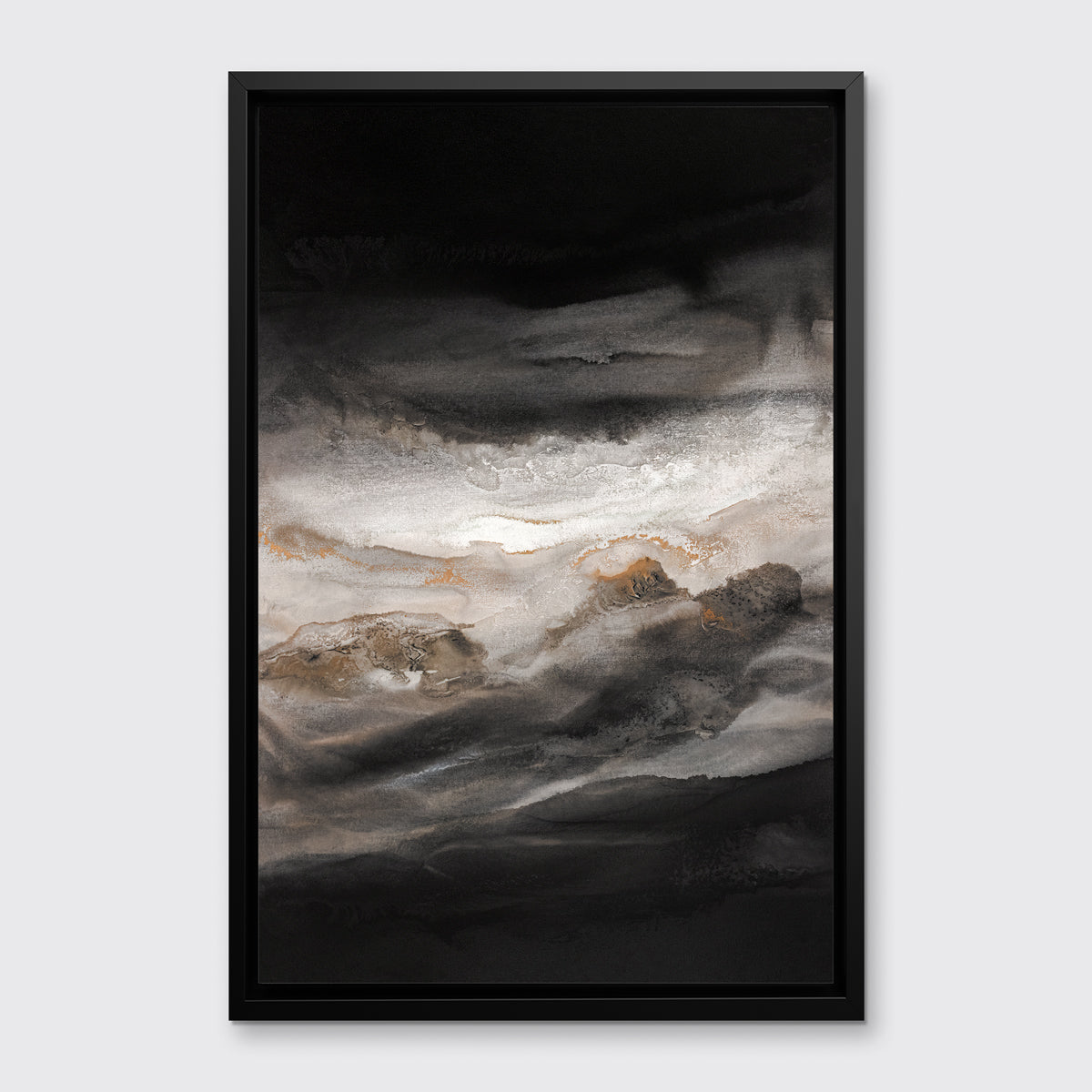A black, white, beige and gold abstract print in a black floater frame hangs on a white wall.