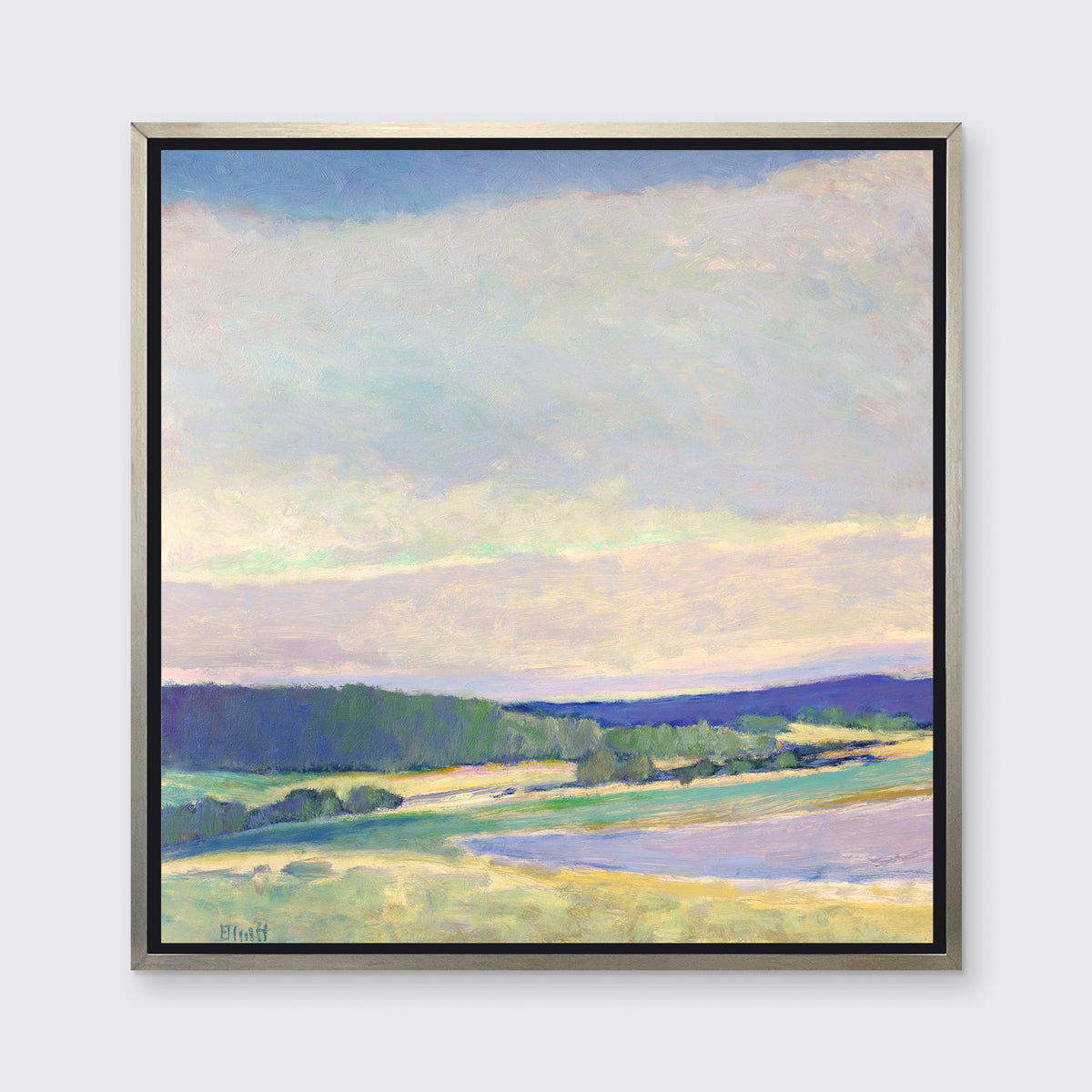 A multicolored abstract landscape print in a silver floater frame hangs on a white wall.