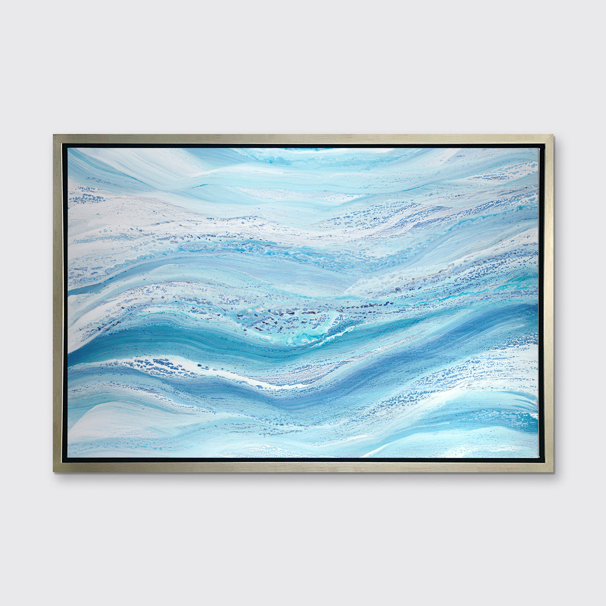 A blue, teal and white abstract print in a silver floater frame hangs on a white wall.