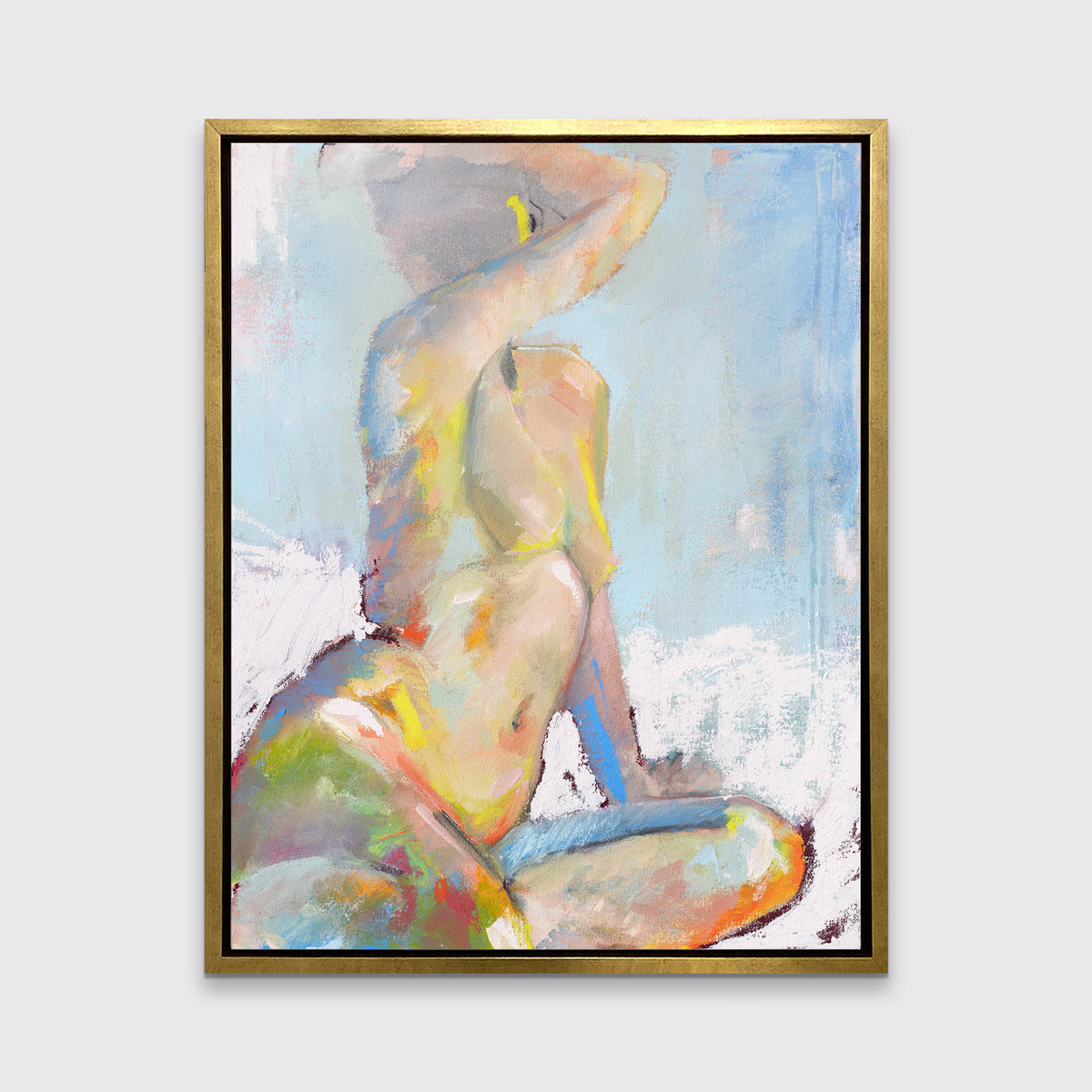 A multicolored abstract figural print in a gold floater frame hangs on a white wall.