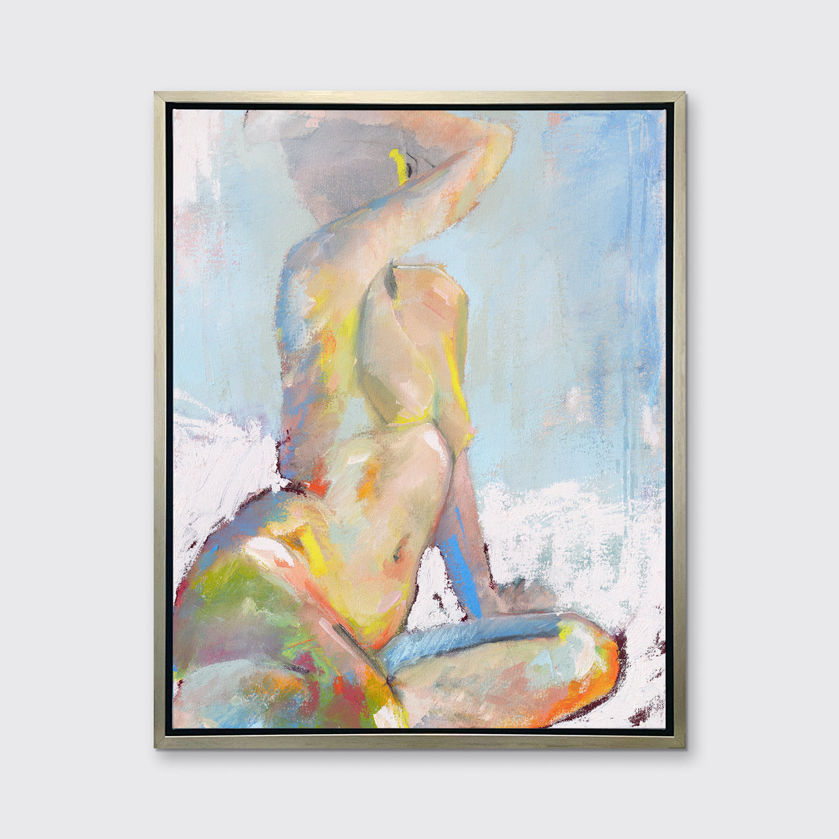 A multicolored abstract figural print in a silver floater frame hangs on a white wall.
