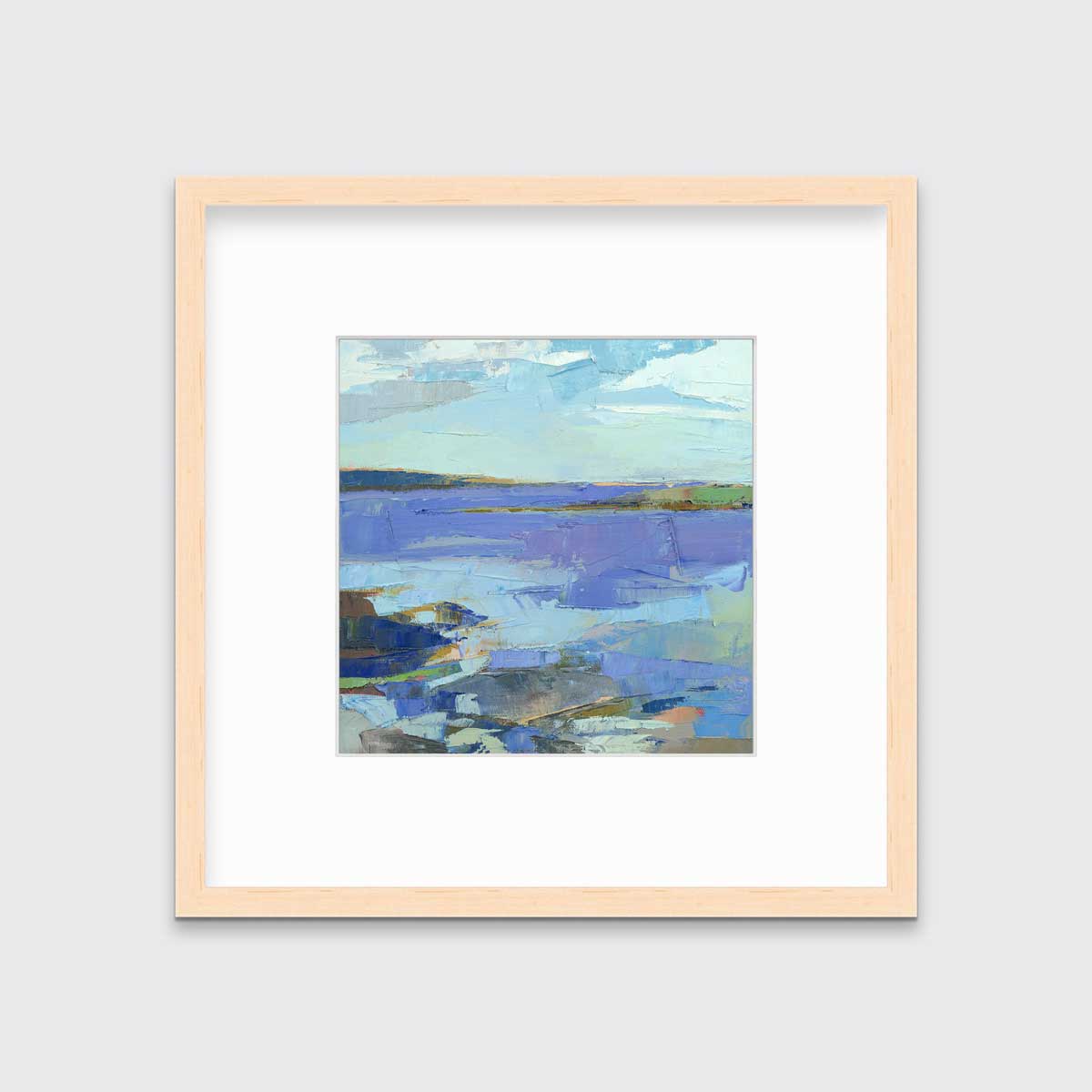 A blue, purple, white and green abstract landscape print in a natural wood frame with a mat hangs on a white wall.