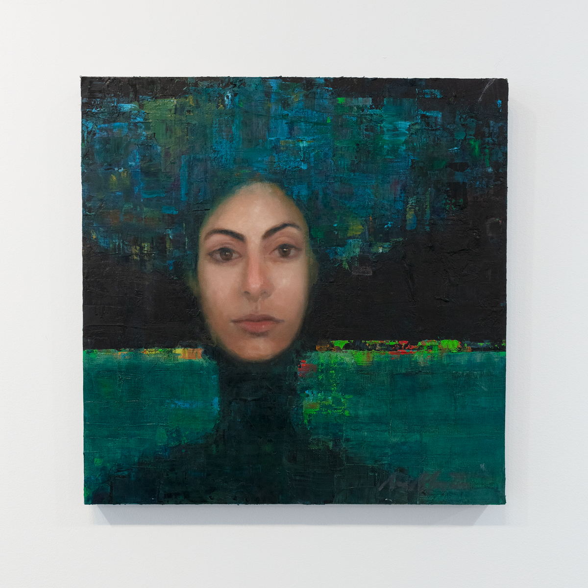 A painting of a woman's face on an abstracted blue and black background is hung on a gallery wall.