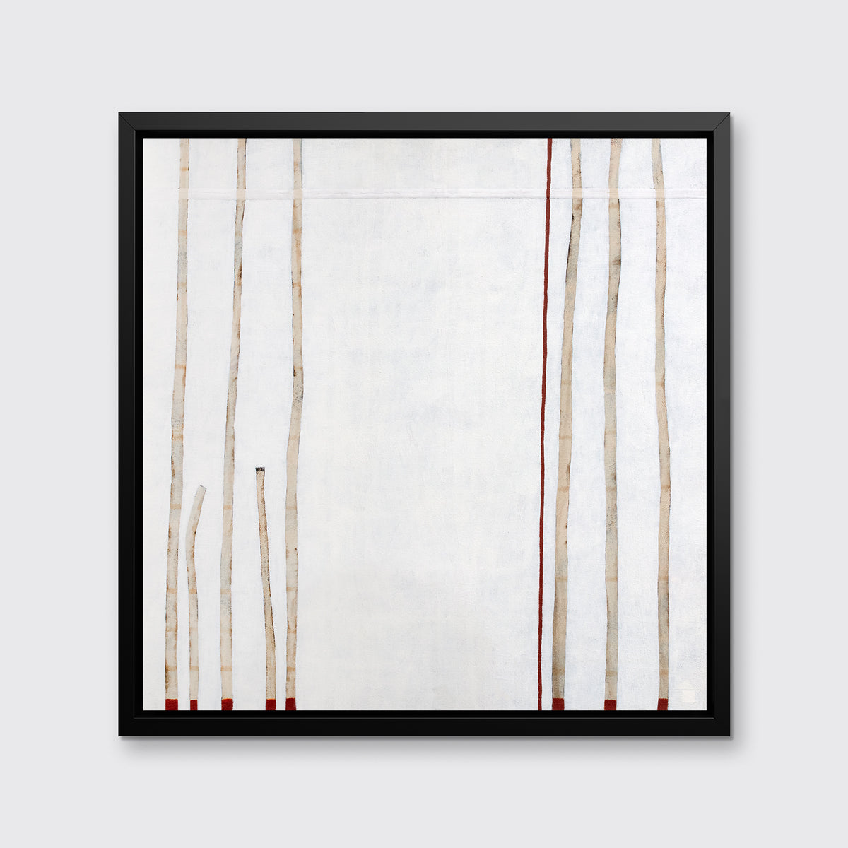 A white, beige and red abstract print in a black floater frame hangs on a white wall.