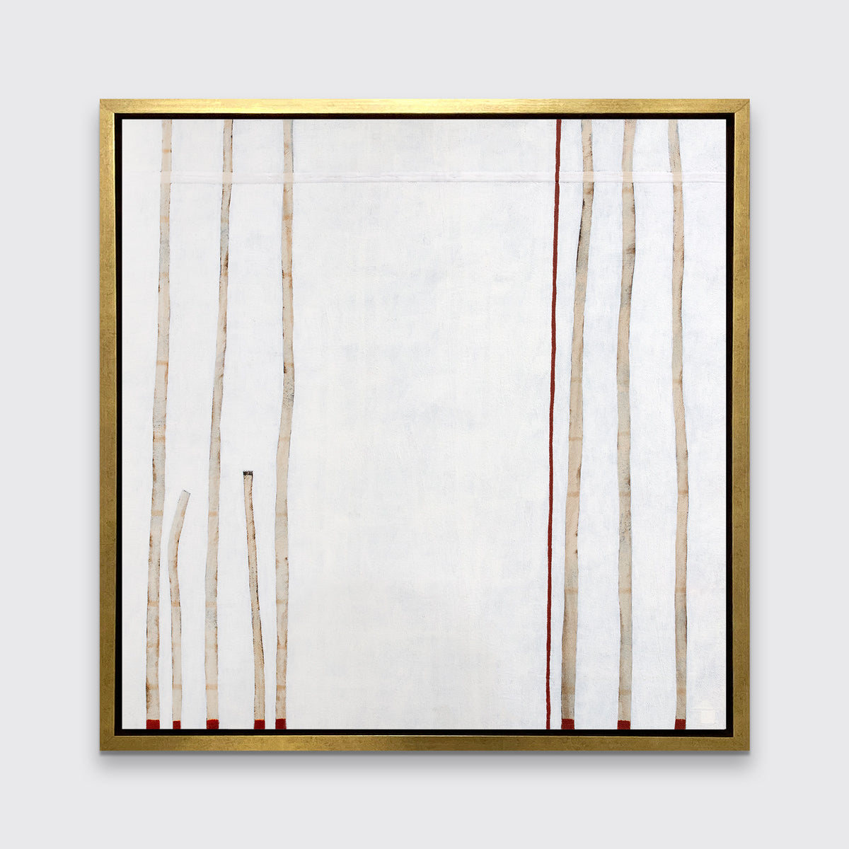 A white, beige and red abstract print in a gold floater frame hangs on a white wall.
