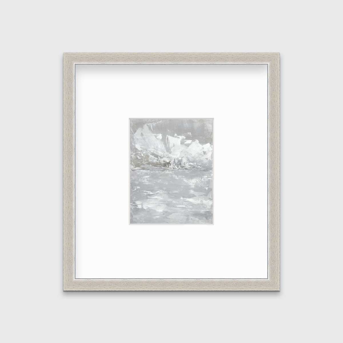 A white and grey abstract print in a silver frame with a mat hangs on a white wall.