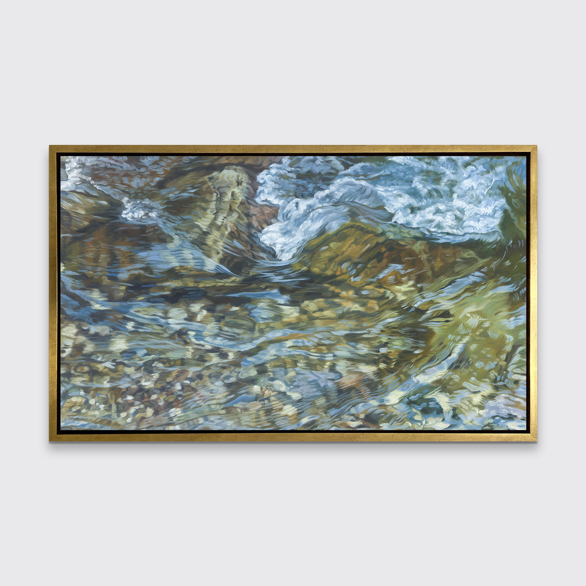 A green, blue, white and tan abstract river rock print in a gold floater frame hangs on a white wall.