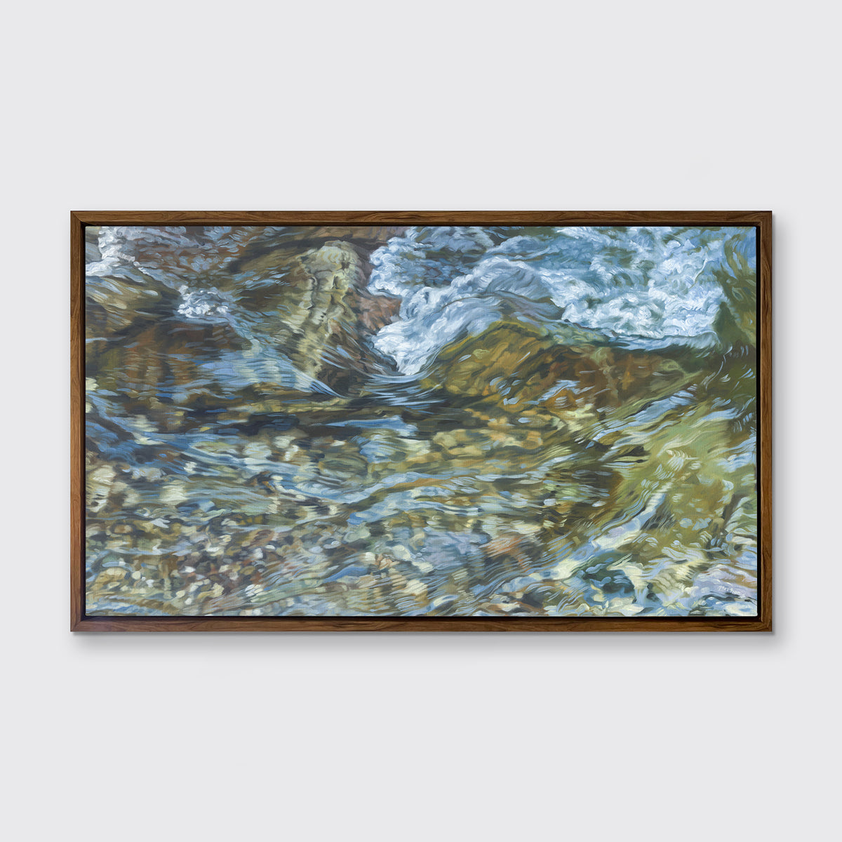A green, blue, white and tan abstract river rock print in an oak wood floater frame hangs on a white wall.