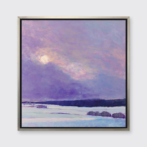 A purple cloudy sky over a snow covered landscape in a silver floater frame hangs on a white wall.