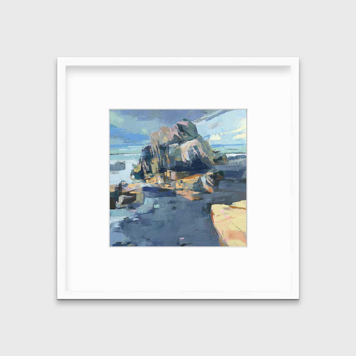 A blue, green and yellow abstract landscape print in a white frame with a mat hangs on a white wall.