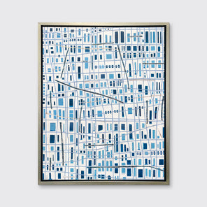 A blue and white geometric abstract print in a silver floater frame hangs on a white wall.