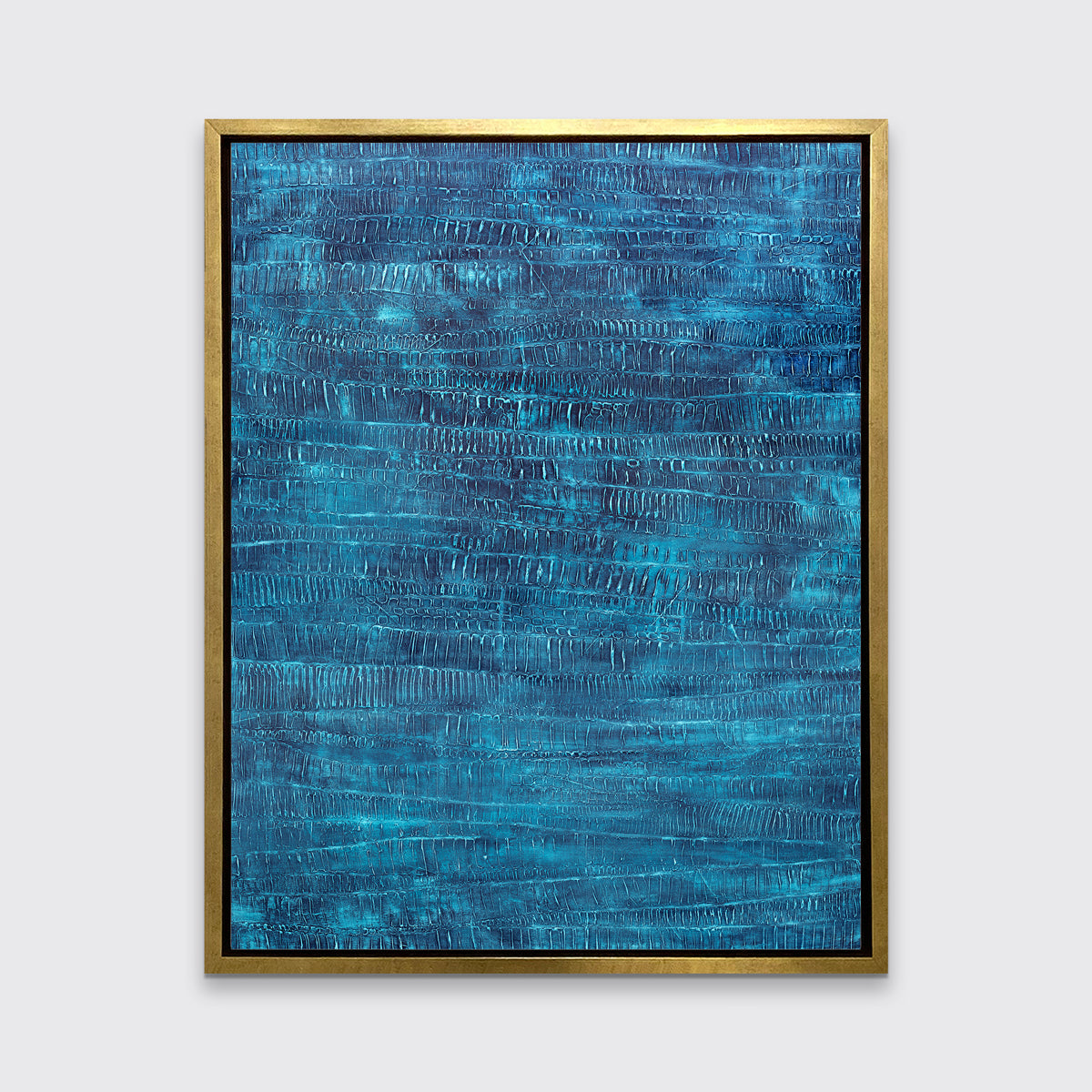 A dark teal abstract print in a gold floater frame hangs on a white wall.