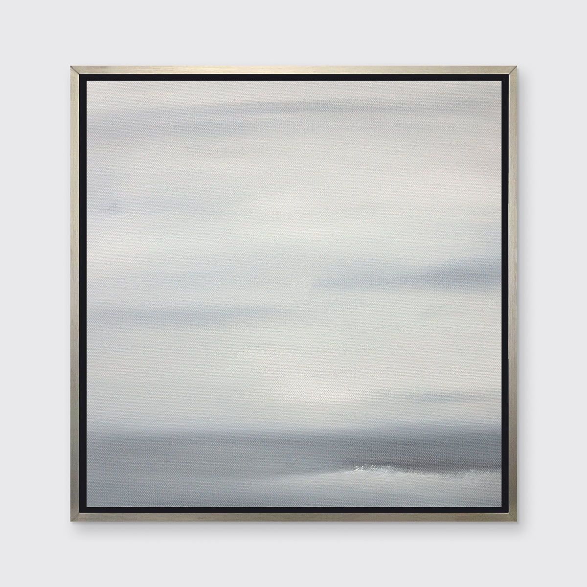A tonal grey print in a silver floater frame hangs on a white wall.