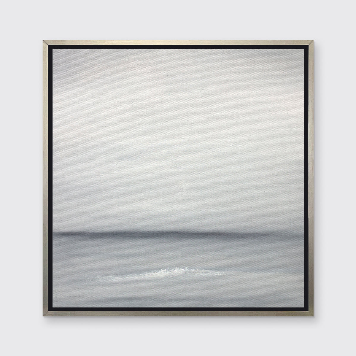 A tonal grey print in a silver floater frame hangs on a white wall.