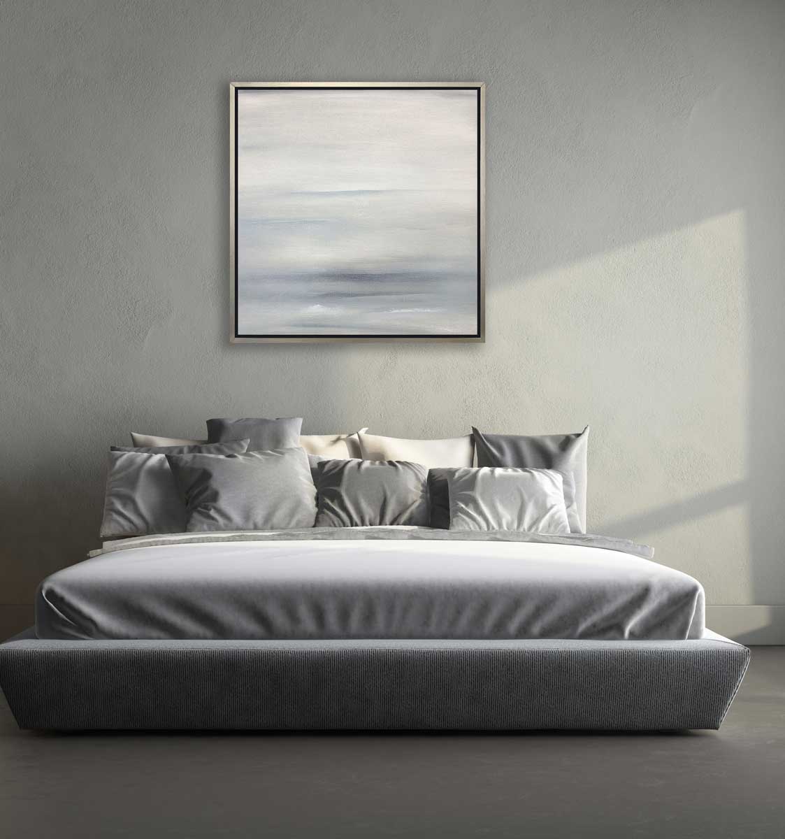 A tonal grey abstract print in a silver floater frame hangs on a grey textured wall above a bed with grey bedding and pillows.