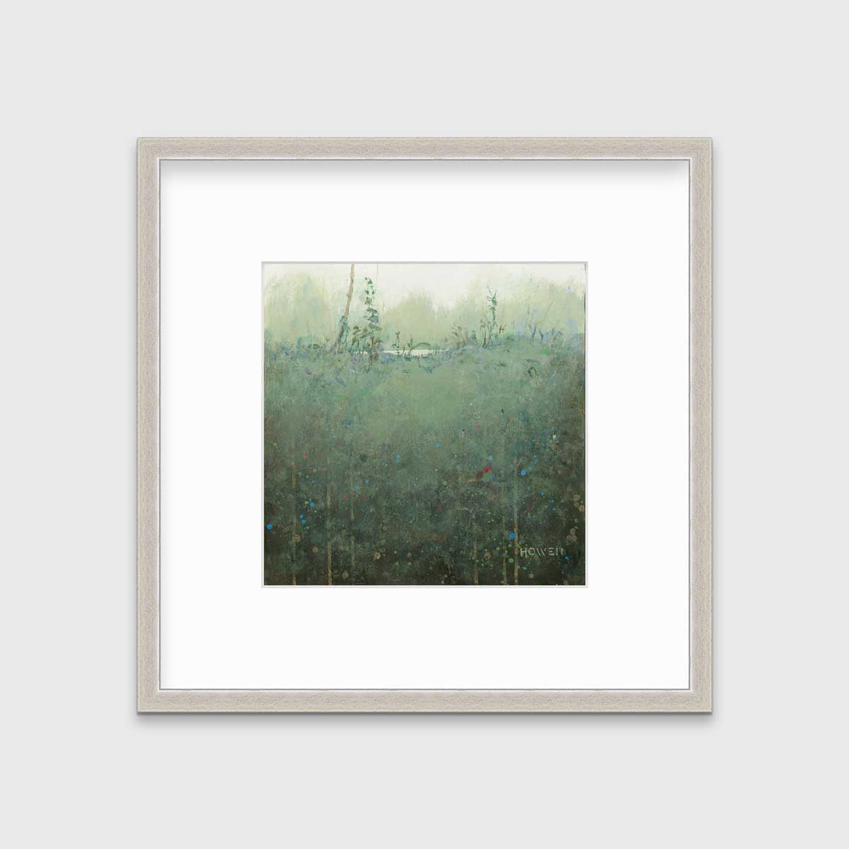 A dark muted green abstract landscape print in a silver frame with a mat hangs on a white wall.