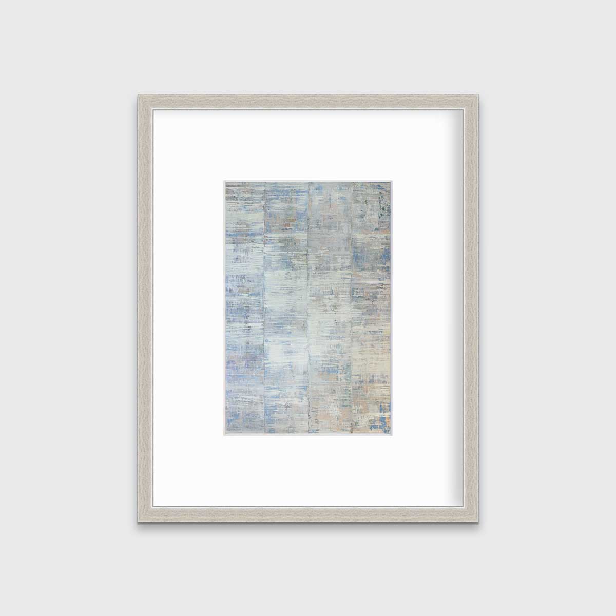A white and blue abstract print in a silver frame with a mat hangs on a white wall.
