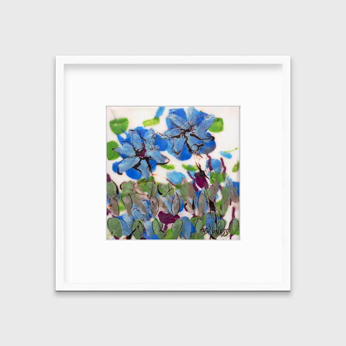 A blue, green and white abstract floral print in a white frame with a mat hangs on a white wall.