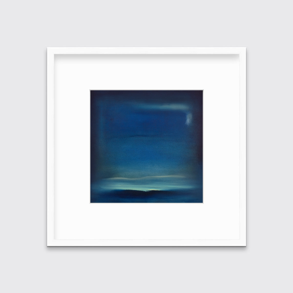 A dark blue and teal with accents of light yellow abstract print in a white frame with a mat hangs on a white wall.