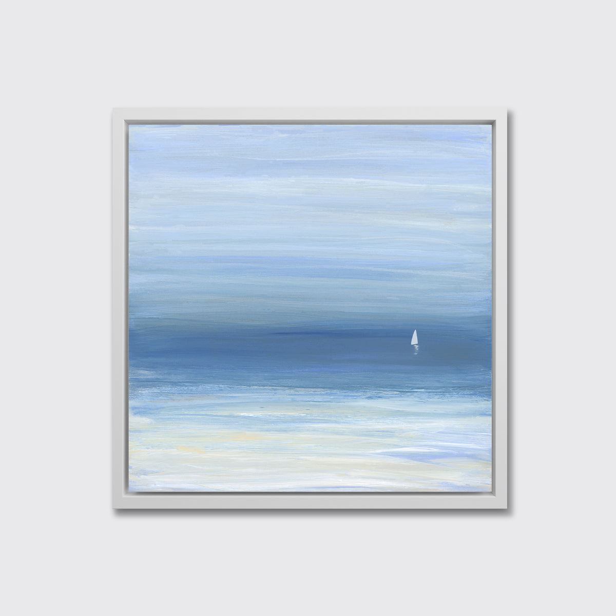 A blue, beige and white abstract seascape print with a small sailboat in a white floater frame hangs on a white wall.