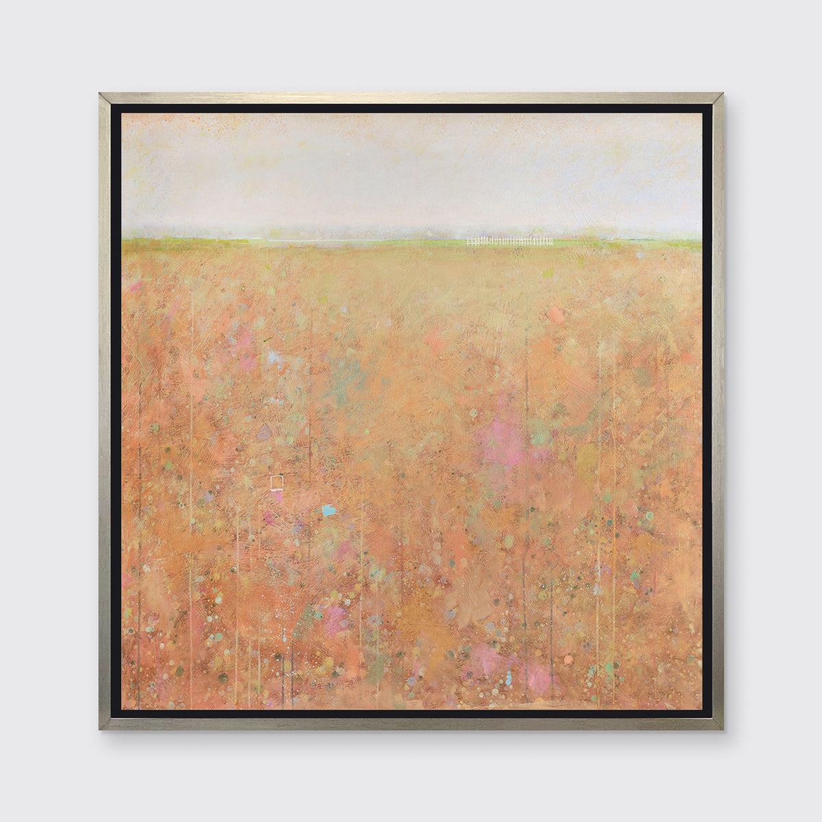 A orange, light green, light blue and pink abstract landscape print in a silver floater frame hangs on a white wall.