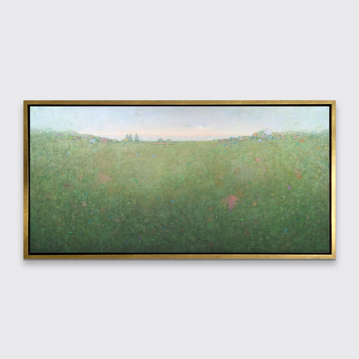 A green abstract landscape print in a gold floater frame hangs on a white wall.