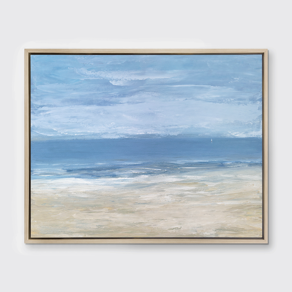 A blue, light blue, white and beige abstract seascape print in a white oak wood floater frame hangs on a white wall.