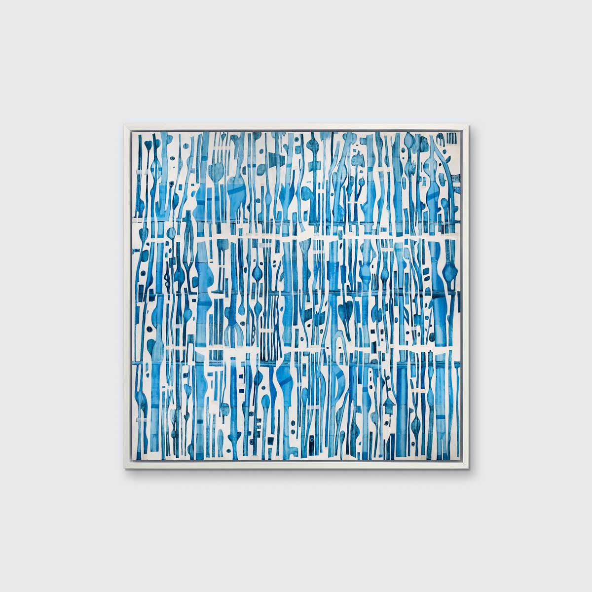A blue and white abstract print in a white floater frame hangs on a white wall.