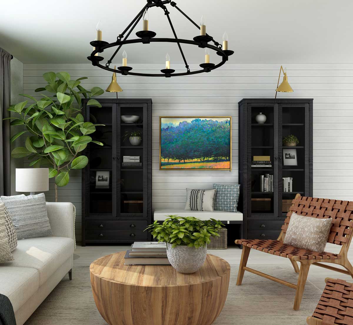 A green, orange and teal abstract tree landscape print in a silver floater frame hangs on a white wall in between two black bookcases, above a white cushioned bench in a living room across from a white linen sofa, a rounded wood coffee table and two basket weave chairs.