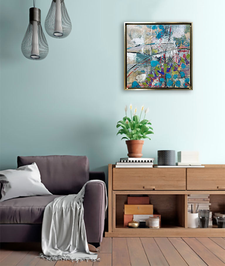 An abstract encaustic painting in a gold frame hangs on a green wall above a wooden console, grey chair, and potted plant.