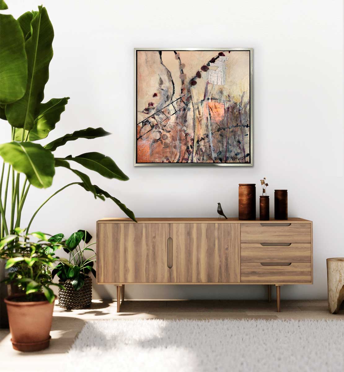A nature inspired print hangs over a mid-century modern conceal. A large group of house plants sit to the left side of the print.